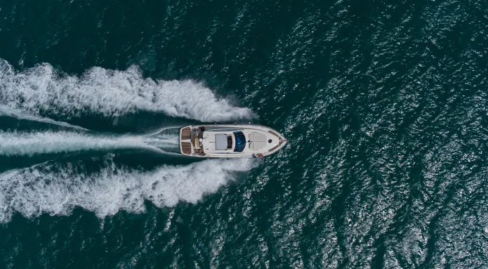 Widok z drona na szybką łódź motorową rozcięającą fale - adrenalinowa przejażdżka speed boat na morzu